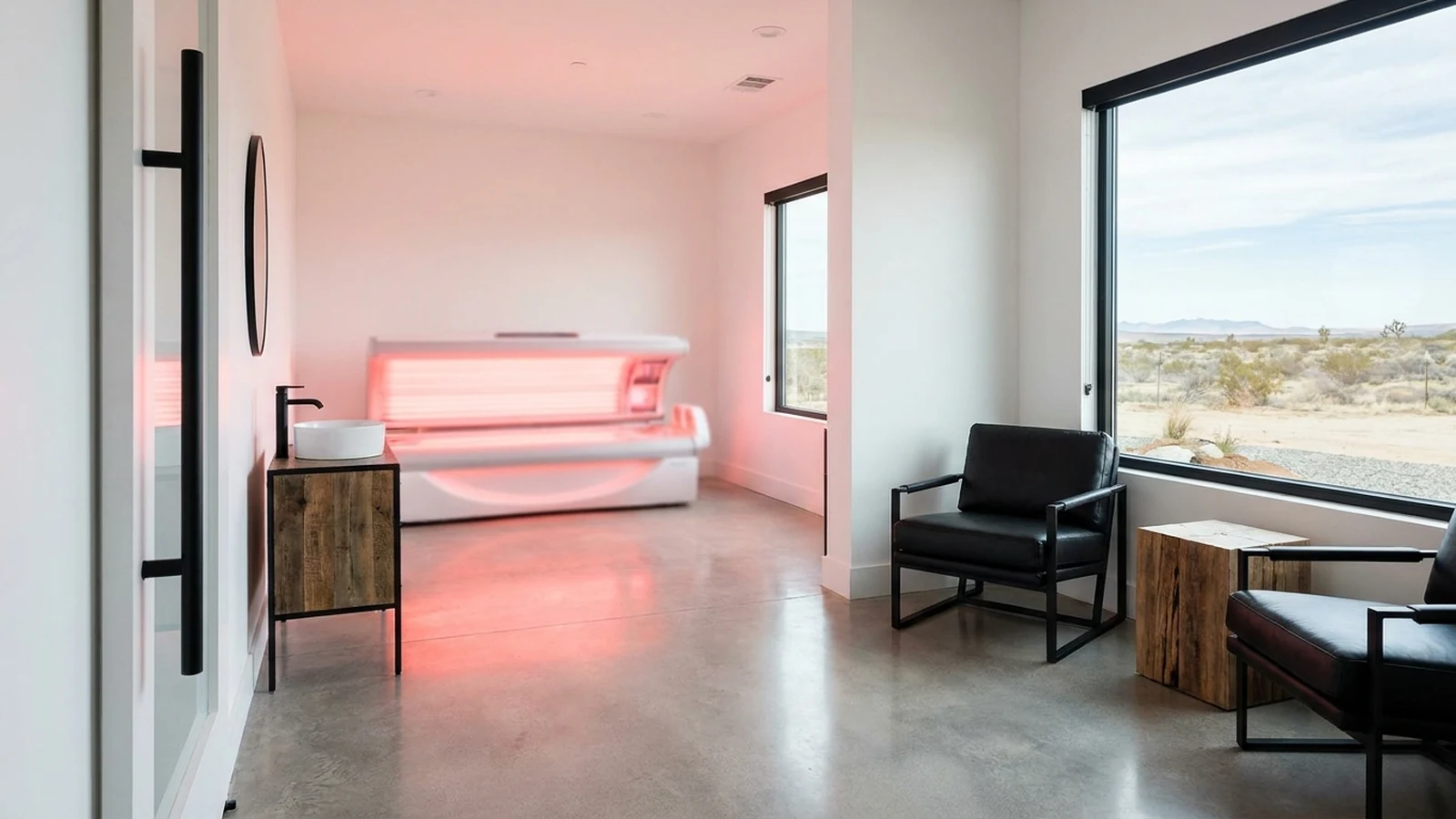Sala de tratamiento de un spa médico con una cama de luz roja encendida al fondo